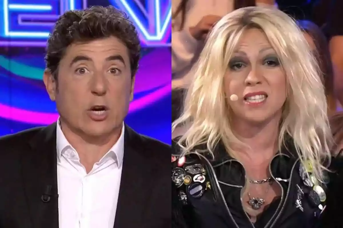 Manel Fuentes y Yenesi en 'Tu cara me suena', una con traje oscuro y camisa blanca, la otra con peluca rubia, chaqueta de cuero y maquillaje llamativo, ambas con micrófono en la mejilla.