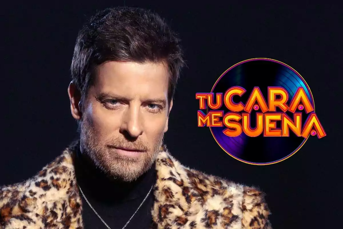 Manu Baqueiro con abrigo de leopardo junto al logo del programa "Tu Cara Me Suena".
