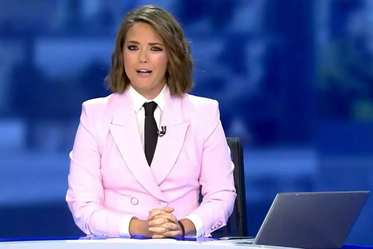 María Casado de noticias con un traje rosa y corbata negra está sentada frente a una computadora portátil en Informativos Telecinco. María Casado de noticias con un traje rosa y corbata negra está sentada frente a una computadora portátil en Informativos Telecinco.