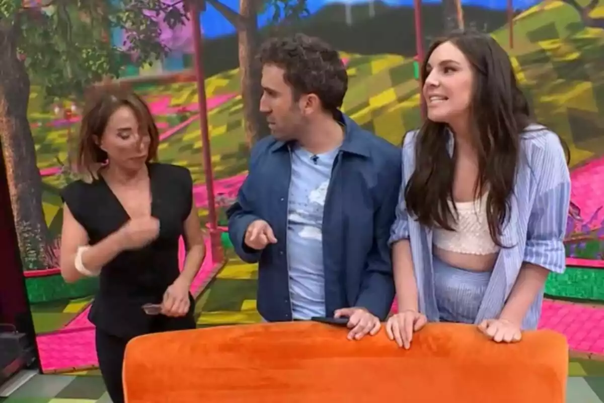 María Patiño, Aitor Albizia i Inés Hernand conversen animadament en un plató acolorit amb un fons d'arbres i patrons geomètrics de La Família de la Tele.