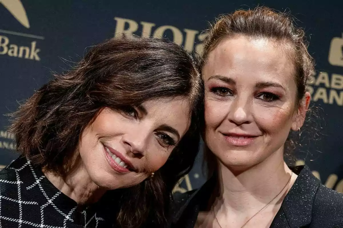 Maribel Verdú i Leonor Watling somrients posen juntes davant d'un fons fosc amb text als Premis Goya.