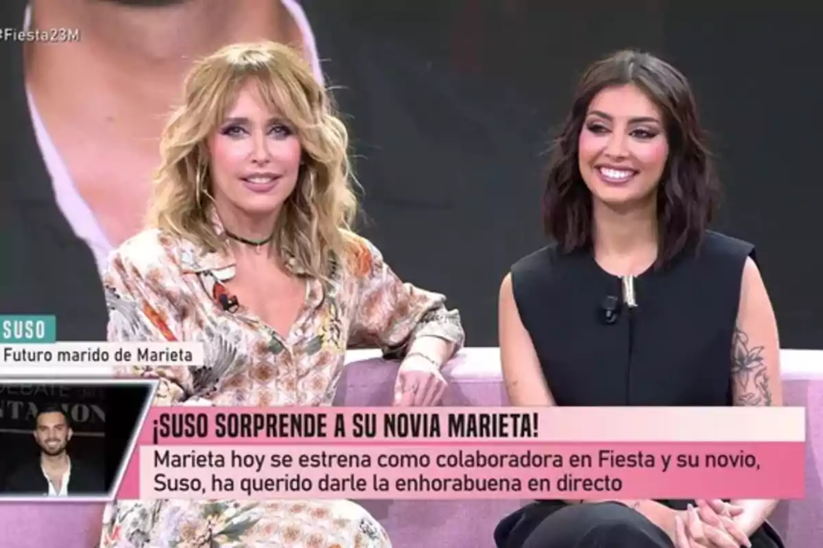 Emma García i Marieta somriuen mentre estan assegudes en un sofà durant un programa de televisió, amb un text en pantalla que menciona una sorpresa de Suso a la seva xicota Marieta. Emma García i Marieta somriuen mentre estan assegudes en un sofà durant un programa de televisió, amb un text en pantalla que menciona una sorpresa de Suso a la seva xicota Marieta.