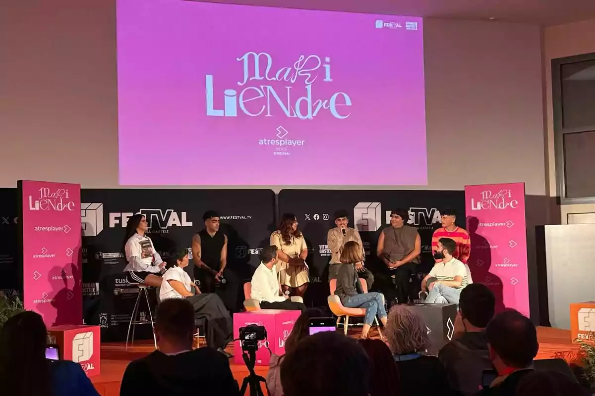 Un grup de persones com Montse García, Emilio Sánchez Zaballos, Martin Urrutia, Omar Ayuso, Blanca Martínez, Ienesi o Carlos González està assegut en un escenari participant en un panell de discussió, amb un cartell rosa de 