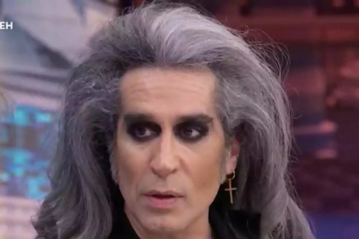 Mario Vaquerizo amb cabell llarg i canós, maquillatge fosc al voltant dels ulls i una arracada en forma de creu a 'El Hormiguero'.