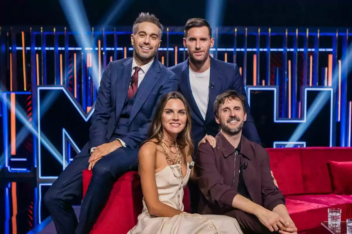Dani Martínez junto a Amaia Salamanca, Julián López y Rudy Fernández posando en el plató de Martínez y Hermanos con luces de fondo y un sofá rojo. Dani Martínez junto a Amaia Salamanca, Julián López y Rudy Fernández posando en el plató de Martínez y Hermanos con luces de fondo y un sofá rojo.