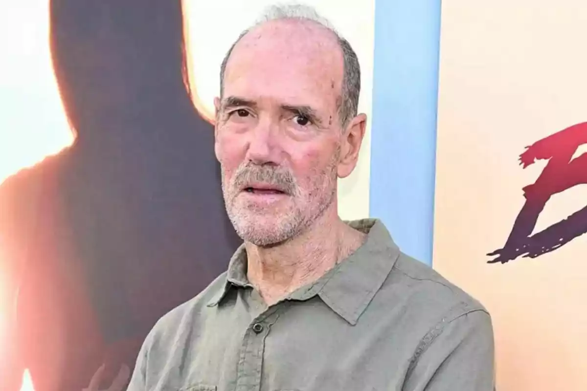 Michael Newman de cabell canós i barba curta vesteix una camisa verda clar i és davant d'un fons amb colors càlids i una silueta. Michael Newman de cabell canós i barba curta vesteix una camisa verda clar i és davant d'un fons amb colors càlids i una silueta.
