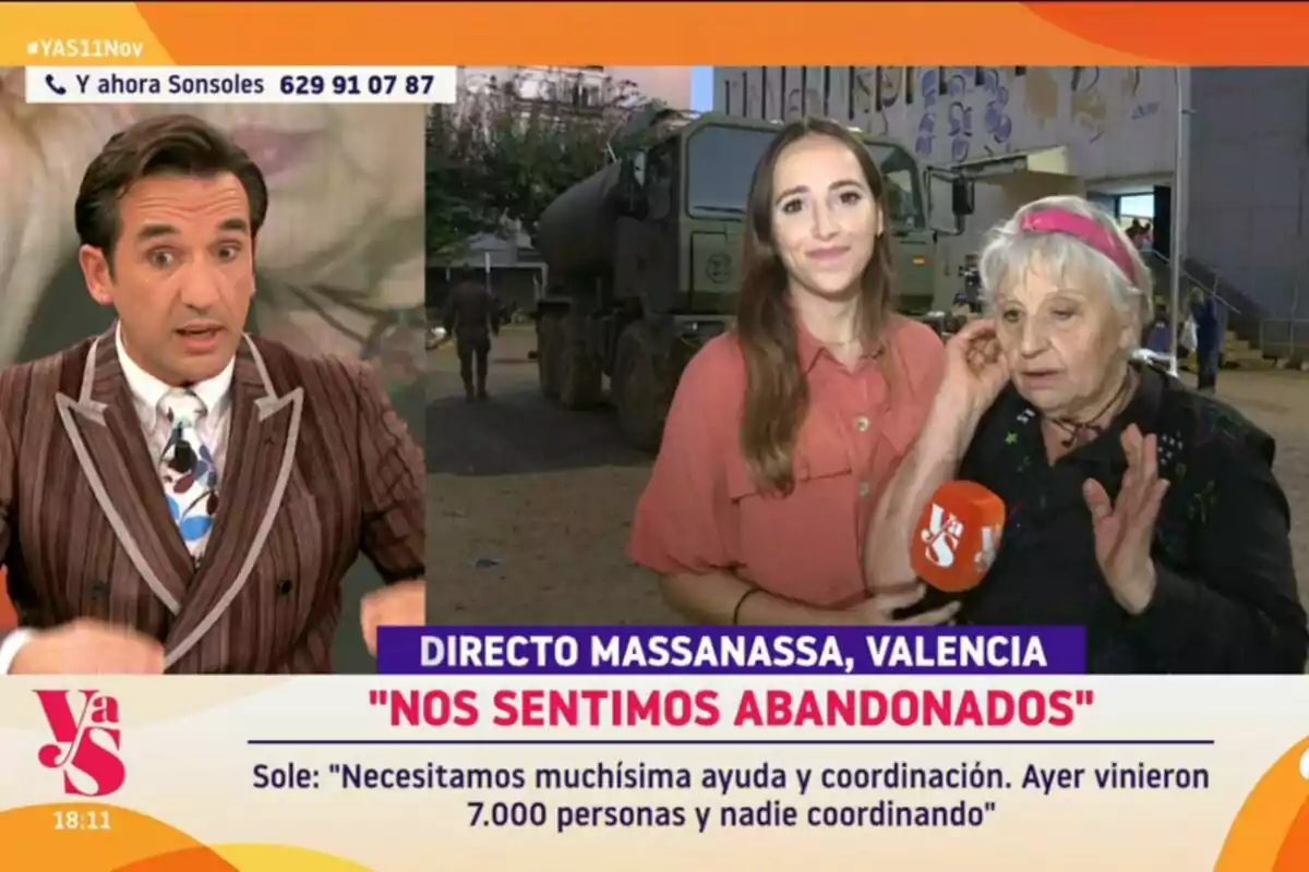 Miguel Lago está en Y ahora Sonsoles mientras una reportera entrevista a una mujer mayor en un lugar al aire libre con un camión militar de fondo. En la pantalla se muestra el texto Miguel Lago está en Y ahora Sonsoles mientras una reportera entrevista a una mujer mayor en un lugar al aire libre con un camión militar de fondo. En la pantalla se muestra el texto
