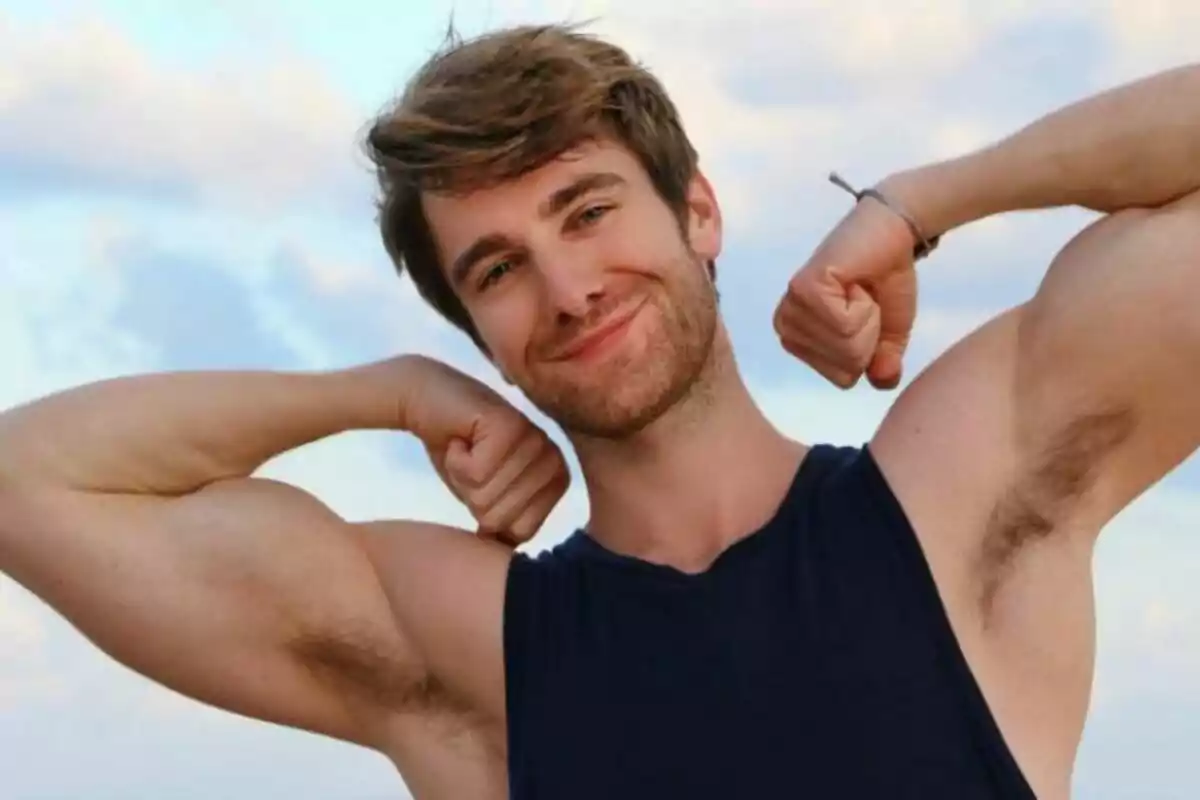 Fotografía de Mike Heslin sonriendo mientras flexiona sus bíceps al aire libre. Fotografía de Mike Heslin sonriendo mientras flexiona sus bíceps al aire libre.