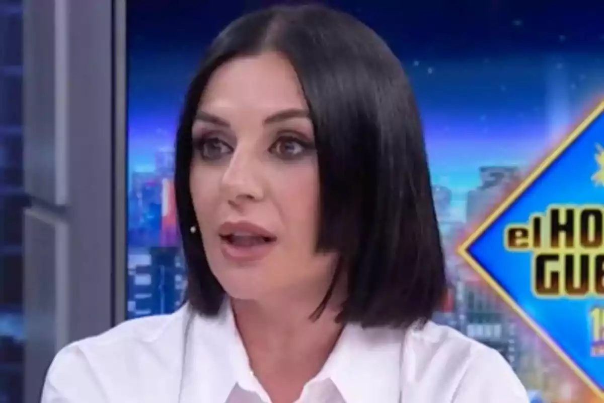 Miren Ibarguren de cabell fosc i llis amb camisa blanca parlant en un programa de televisió amb el logotip d’El Hormiguero al fons