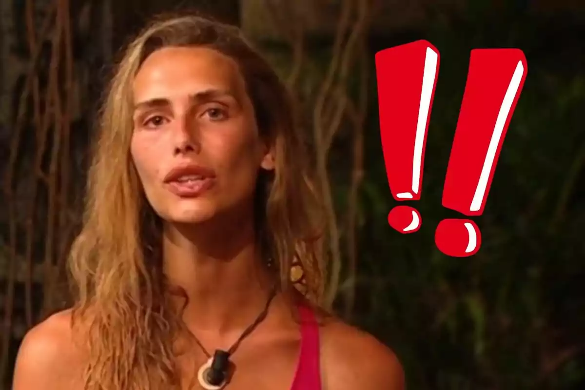 Ángela Ponce está hablando frente a un fondo oscuro con signos de exclamación rojos al lado.