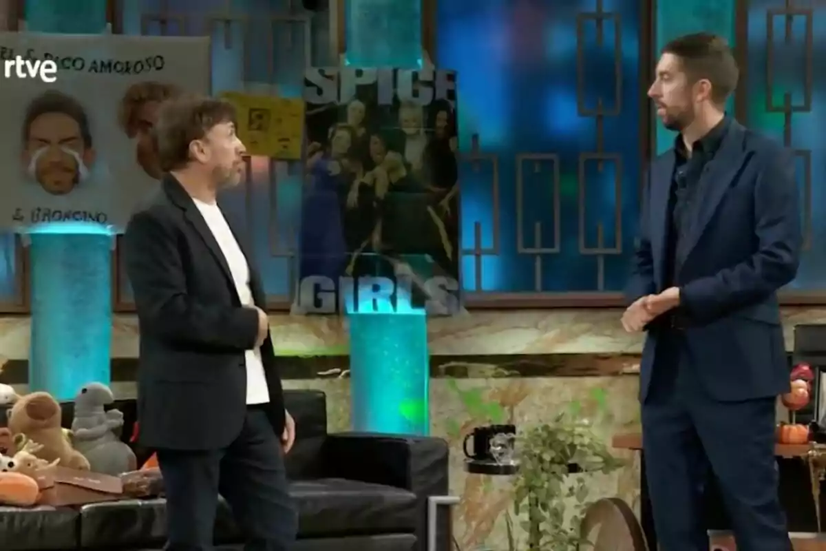 José Mota y David Broncano conversan en un set de televisión decorado con carteles y peluches en 'La Revuelta'. José Mota y David Broncano conversan en un set de televisión decorado con carteles y peluches en 'La Revuelta'.