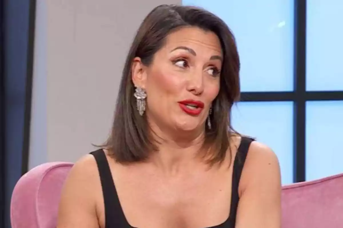 Nagore Robles amb cabell fosc i arracades grans està asseguda en un sofà rosa, parlant en un entorn interior. Nagore Robles amb cabell fosc i arracades grans està asseguda en un sofà rosa, parlant en un entorn interior.