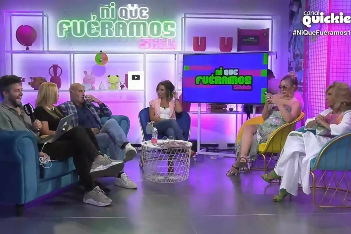 Los colaboradores están sentados en el set de 'Ni que fuéramos' colorido con el letrero en la pared y una pantalla que muestra el mismo texto, mientras conversan y se ríen. Captura el 17 de julio de 2024 Los colaboradores están sentados en el set de 'Ni que fuéramos' colorido con el letrero en la pared y una pantalla que muestra el mismo texto, mientras conversan y se ríen. Captura el 17 de julio de 2024