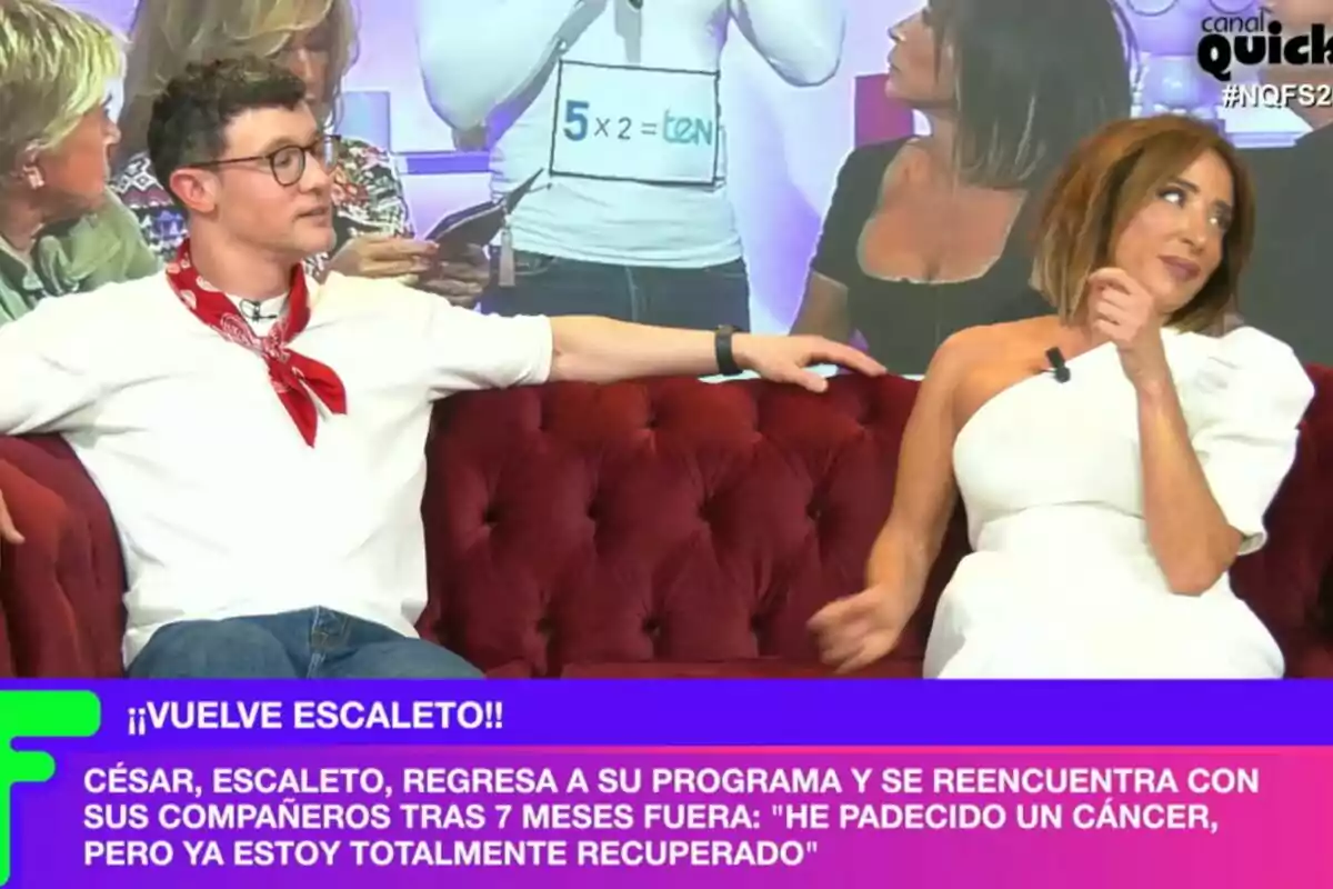 María Patiño y Escaleto están sentados en un sofá rojo durante Ni que fuéramos, con un texto en la parte inferior que anuncia el regreso de una persona al programa después de recuperarse de una enfermedad. María Patiño y Escaleto están sentados en un sofá rojo durante Ni que fuéramos, con un texto en la parte inferior que anuncia el regreso de una persona al programa después de recuperarse de una enfermedad.