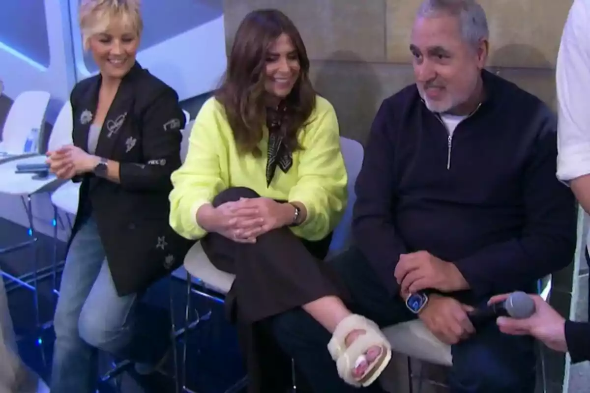 Cristina Pardo, Nuria Roca y Jorge Salvador sentados en sillas altas, dos mujeres y un hombre, están sonriendo y conversando mientras Nuria Roca enseña su pie con una venda en un ambiente moderno y luminoso en El Hormiguero. Cristina Pardo, Nuria Roca y Jorge Salvador sentados en sillas altas, dos mujeres y un hombre, están sonriendo y conversando mientras Nuria Roca enseña su pie con una venda en un ambiente moderno y luminoso en El Hormiguero.