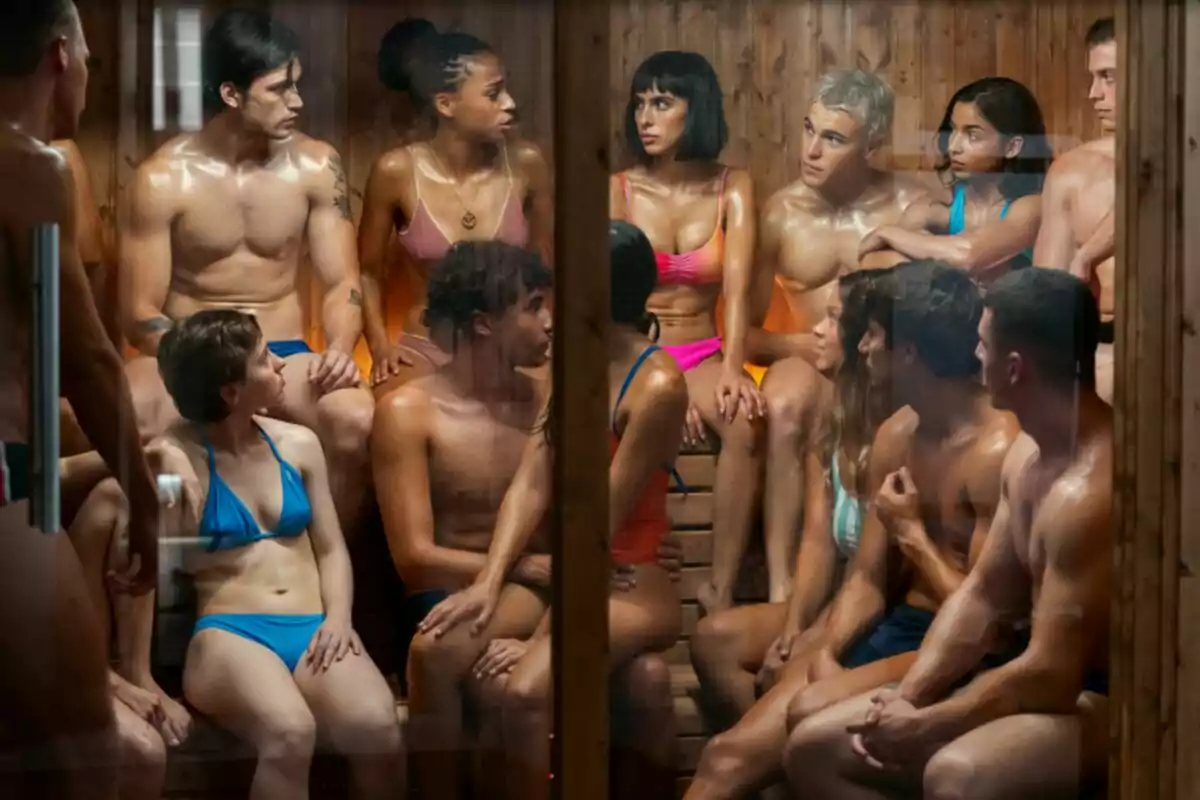Un grupo de personas en trajes de baño están sentadas en una sauna de madera, conversando entre ellas en Olympo.