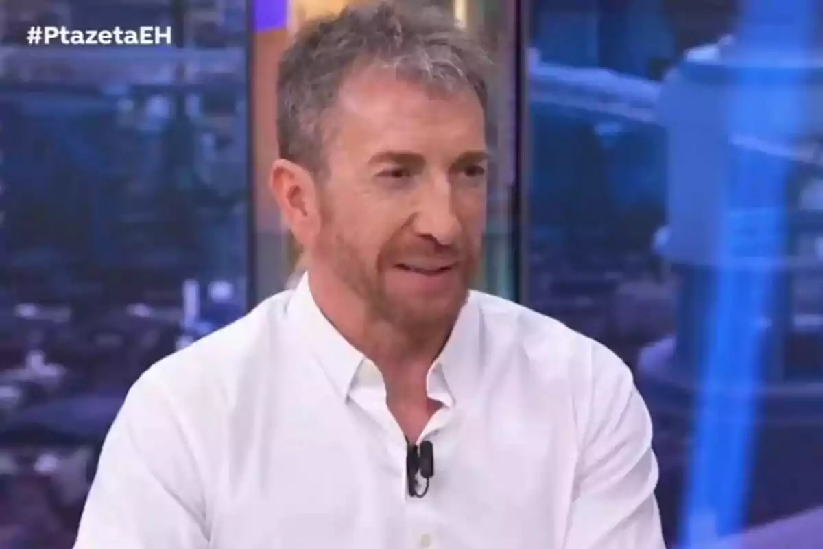Pablo Motos con barba y cabello canoso lleva una camisa blanca y está sentado en el plató de El Hormiguero. Pablo Motos con barba y cabello canoso lleva una camisa blanca y está sentado en el plató de El Hormiguero.