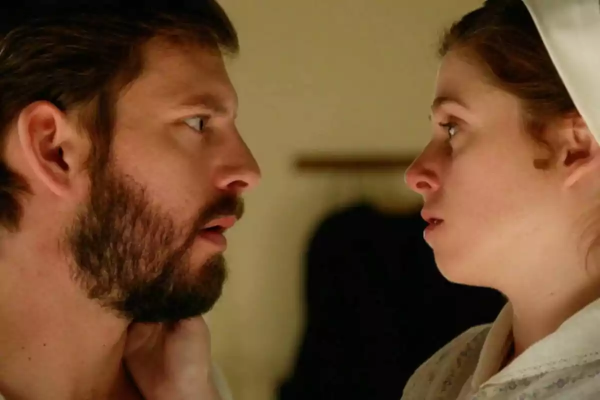 El padre Samuel y María se miran fijamente a los ojos con expresiones serias en un ambiente interior iluminado, en una escena de 'La Promesa'. El padre Samuel y María se miran fijamente a los ojos con expresiones serias en un ambiente interior iluminado, en una escena de 'La Promesa'.
