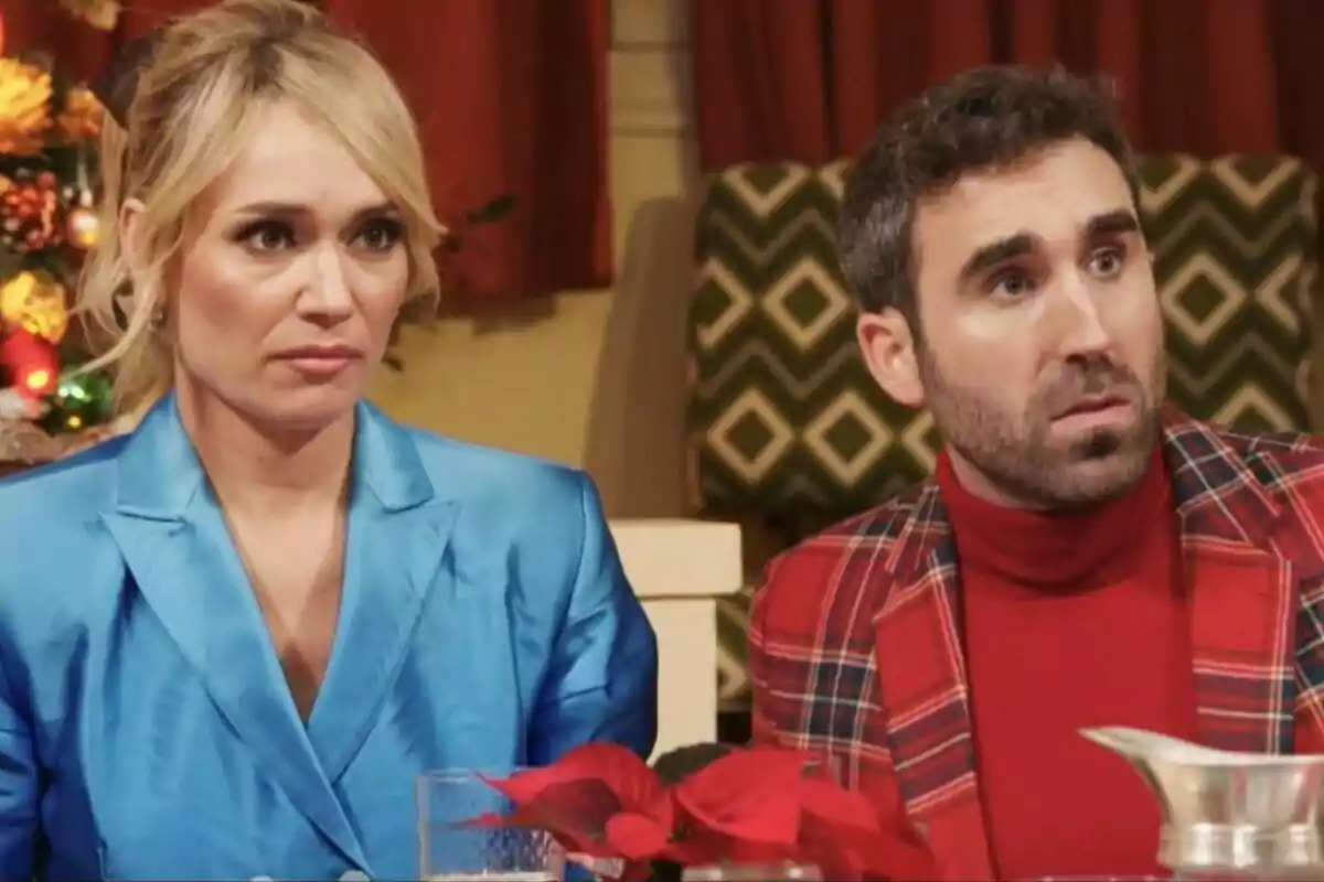Patricia Conde y Aitor Albizua sentadas en una mesa con expresiones serias, una mujer con chaqueta azul y un hombre con chaqueta de cuadros rojos, con decoraciones navideñas al fondo en Telepasión. Patricia Conde y Aitor Albizua sentadas en una mesa con expresiones serias, una mujer con chaqueta azul y un hombre con chaqueta de cuadros rojos, con decoraciones navideñas al fondo en Telepasión.