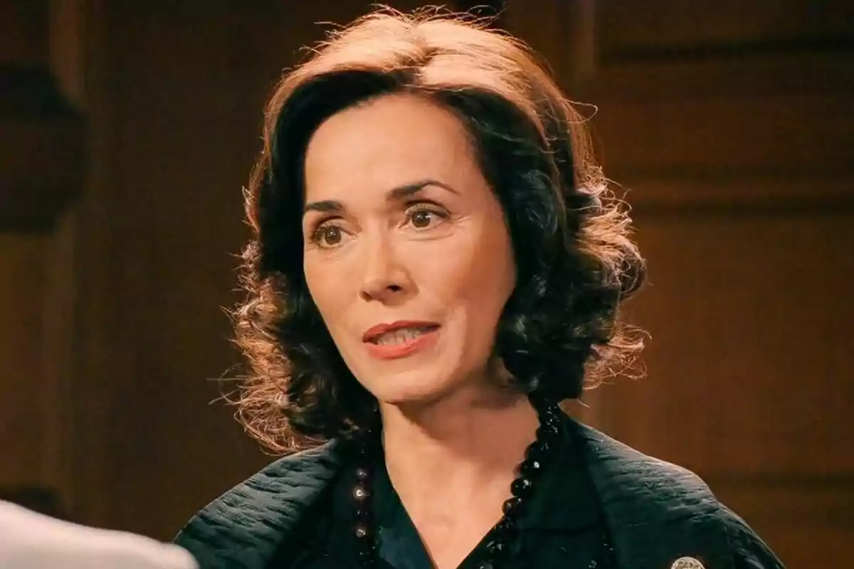 Patricia Lambert de cabello oscuro y rizado con expresión seria lleva un collar de cuentas negras y está en un ambiente interior en Sueños de Libertad. Patricia Lambert de cabello oscuro y rizado con expresión seria lleva un collar de cuentas negras y está en un ambiente interior en Sueños de Libertad.