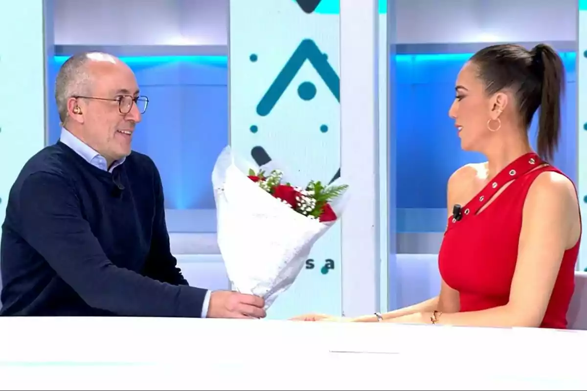 Alfonso Egea entrega un ramo de flores a Patricia Pardo en Vamos a ver, ambos están sonriendo y sentados frente a frente. Alfonso Egea entrega un ramo de flores a Patricia Pardo en Vamos a ver, ambos están sonriendo y sentados frente a frente.