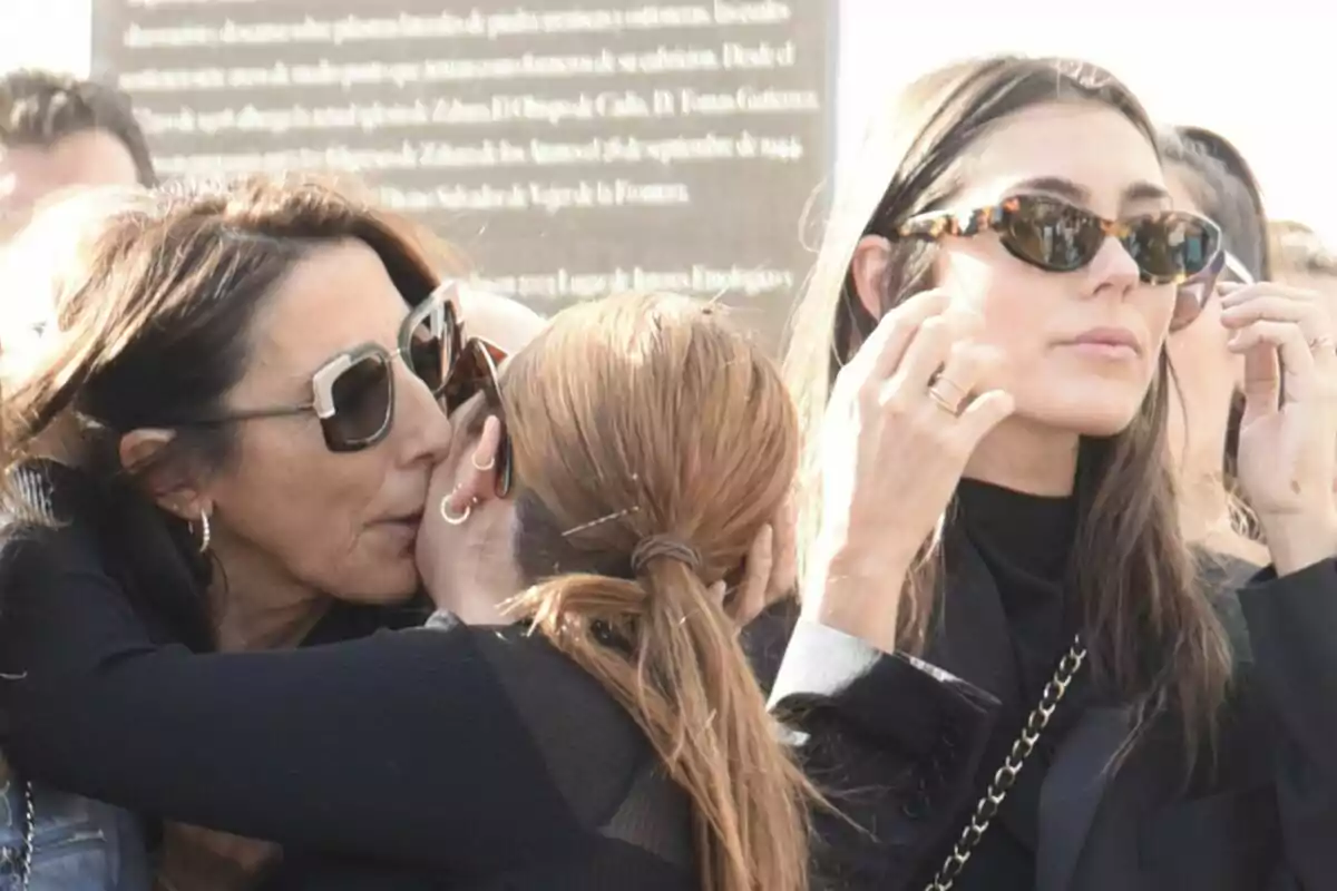 Paz Padilla y Anna Ferrer Padilla con gafas de sol interactúa en un ambiente al aire libre en un funeral. Paz Padilla y Anna Ferrer Padilla con gafas de sol interactúa en un ambiente al aire libre en un funeral.
