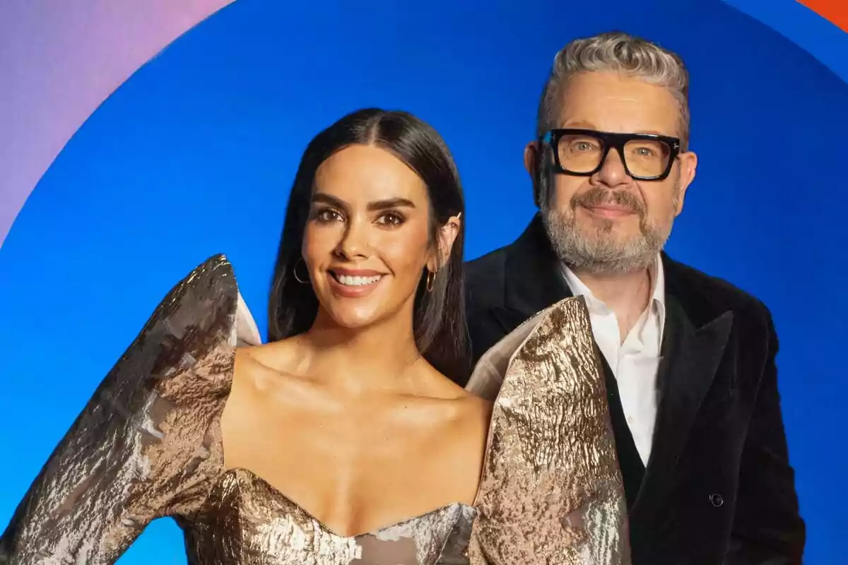 Cristina Pedroche y Alberto Chicote posando juntas en un fondo azul con un arco iris estilizado. Cristina Pedroche y Alberto Chicote posando juntas en un fondo azul con un arco iris estilizado.