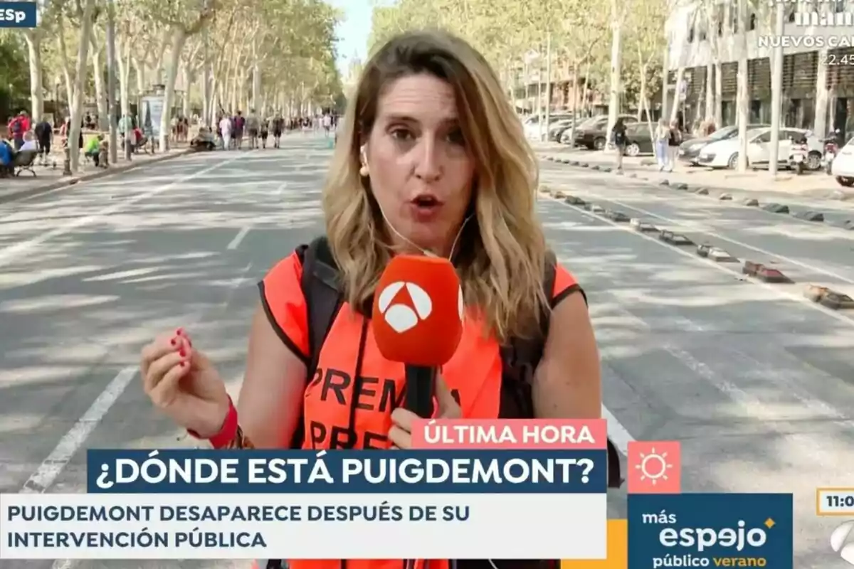 Captura de una reportera de Antena 3 Noticias en Espejo Público con un chaleco naranja y un micrófono está informando en una calle arbolada con el titular Captura de una reportera de Antena 3 Noticias en Espejo Público con un chaleco naranja y un micrófono está informando en una calle arbolada con el titular