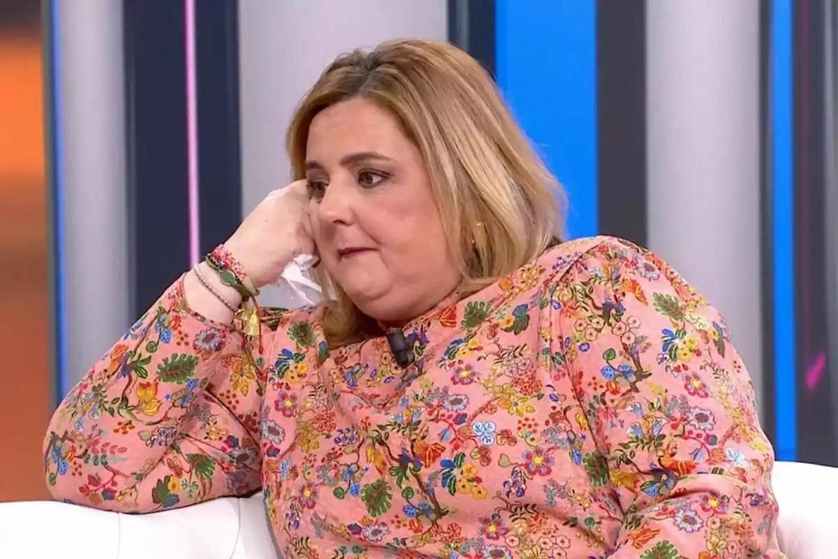 Pilar Vidal con expresión pensativa sentada en un sofá con fondo de colores verticales de Y ahora Sonsoles. Pilar Vidal con expresión pensativa sentada en un sofá con fondo de colores verticales de Y ahora Sonsoles.