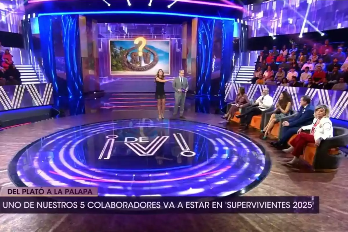 Plató de De Viernes con un diseño moderno y colorido, Santi Acosta y Beatriz Archidona están de pie en el centro mientras un grupo de colaboradores con Angela Portero, José Antonio León, Patricia Pérez, Antonio Montero y Terelu Campos está sentado a un lado, con una pantalla al fondo que muestra un logotipo y un signo de interrogación, y un mensaje en la parte inferior que menciona la participación de uno de los colaboradores en Supervivientes. Plató de De Viernes con un diseño moderno y colorido, Santi Acosta y Beatriz Archidona están de pie en el centro mientras un grupo de colaboradores con Angela Portero, José Antonio León, Patricia Pérez, Antonio Montero y Terelu Campos está sentado a un lado, con una pantalla al fondo que muestra un logotipo y un signo de interrogación, y un mensaje en la parte inferior que menciona la participación de uno de los colaboradores en Supervivientes.