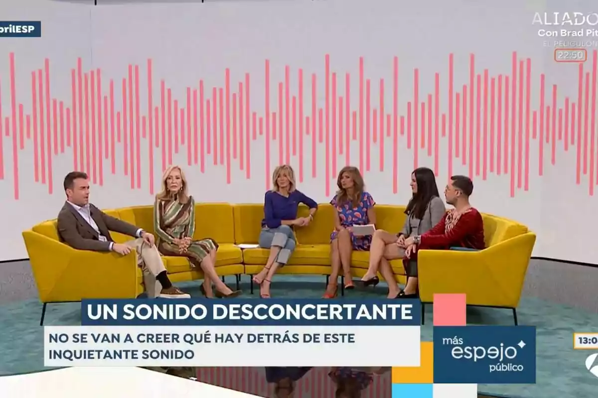Colaboradores y presentadora están sentados en un sofá amarillo en 'Espejo público', con un gráfico de ondas sonoras en la pared detrás de ellos y un texto en pantalla que dice Colaboradores y presentadora están sentados en un sofá amarillo en 'Espejo público', con un gráfico de ondas sonoras en la pared detrás de ellos y un texto en pantalla que dice
