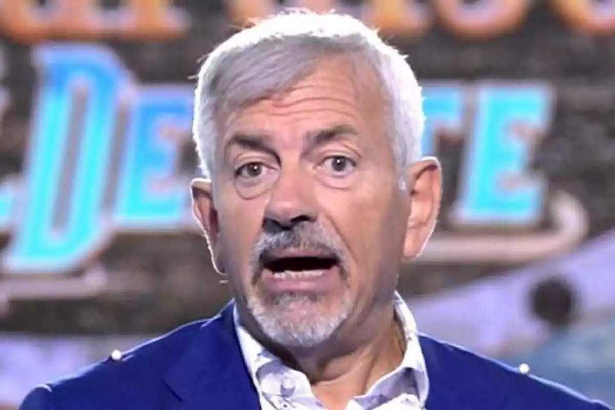 Primer plano de Carlos Sobera hablando a cámara con el rostro serio en un plató de televisión