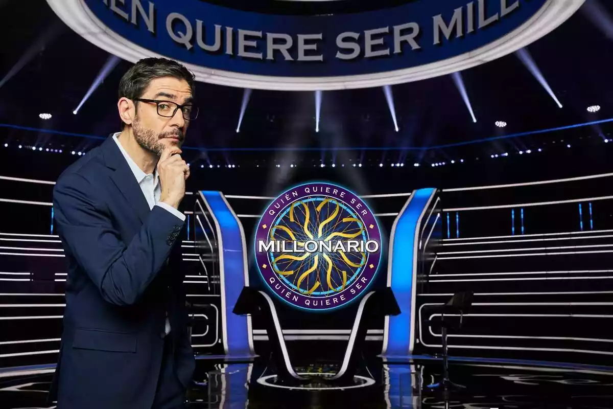Fotografía de Juanra Bonet mirando a cámara con el logo de ¿Quién quiere ser millonario? de laSexta Fotografía de Juanra Bonet mirando a cámara con el logo de ¿Quién quiere ser millonario? de laSexta