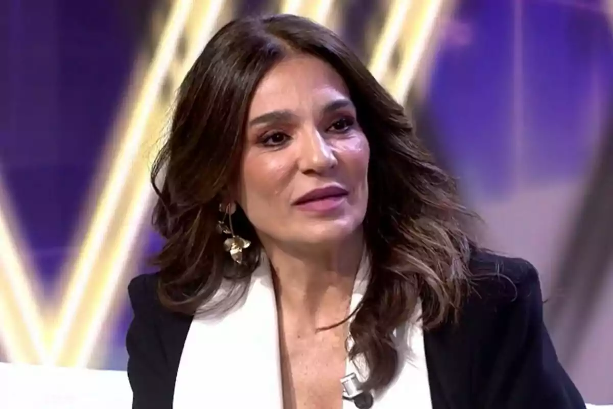 Raquel Bolo con cabello oscuro y suelto, usando un blazer negro y blusa blanca, en un entorno iluminado en De Viernes. Raquel Bolo con cabello oscuro y suelto, usando un blazer negro y blusa blanca, en un entorno iluminado en De Viernes.