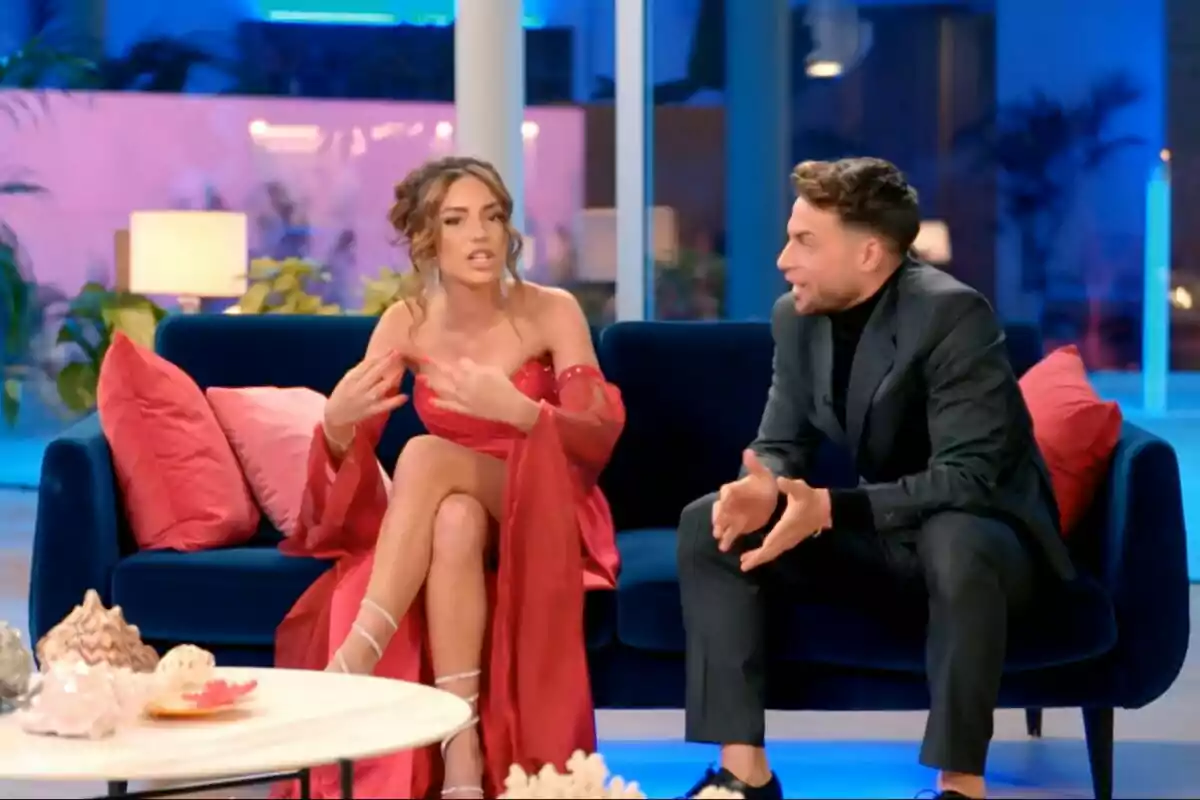 Anita Williams y Montoya sentadas en un sofá azul conversan animadamente en un ambiente moderno y colorido en La Isla de las Tentaciones. Anita Williams y Montoya sentadas en un sofá azul conversan animadamente en un ambiente moderno y colorido en La Isla de las Tentaciones.