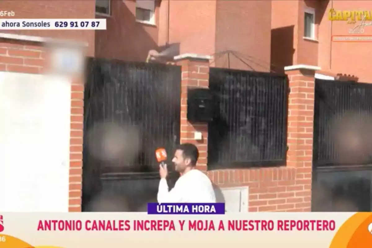 Un reportero con un micrófono es mojado por una persona desde una casa mientras realiza una transmisión en vivo en 'Y ahora Sonsoles'. Un reportero con un micrófono es mojado por una persona desde una casa mientras realiza una transmisión en vivo en 'Y ahora Sonsoles'.