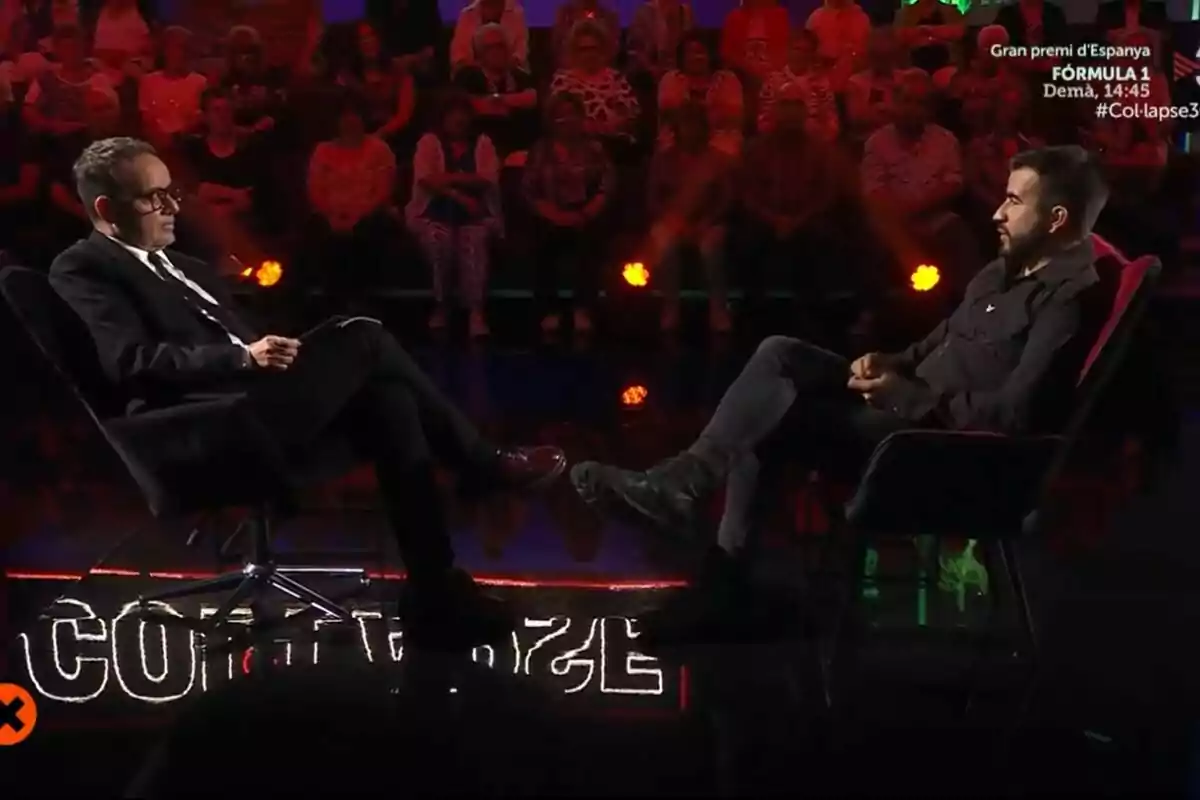 Ricard Ustrell i Àngel Llàcer asseguts l’un davant de l’altre en un plató de televisió de Col·lapse amb públic al fons i llums tènues a TV3.