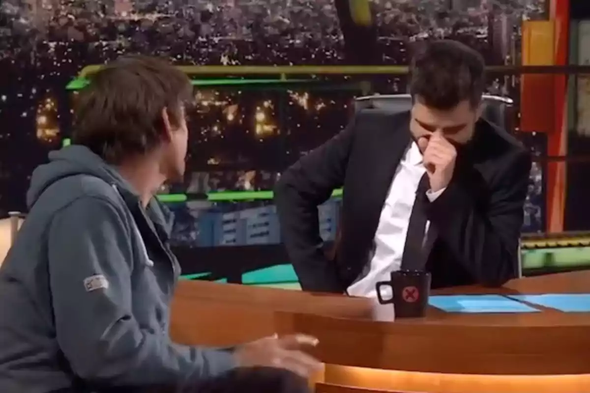 Ricard Ustrell y Albert Pla conversan en un set de televisión nocturno, una de ellas se ríe mientras la otra está de espaldas. Ricard Ustrell y Albert Pla conversan en un set de televisión nocturno, una de ellas se ríe mientras la otra está de espaldas.