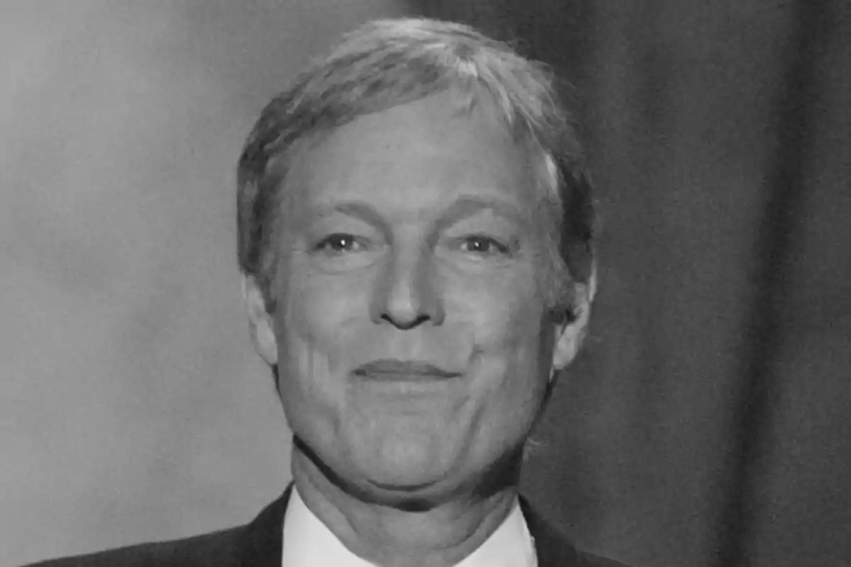 Richard Chamberlain de cabello corto y canoso sonríe ligeramente en una fotografía en blanco y negro.