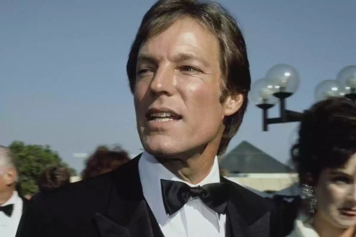 Richard Chamberlain home amb esmòquing i llacet negre en un esdeveniment a l'aire lliure.