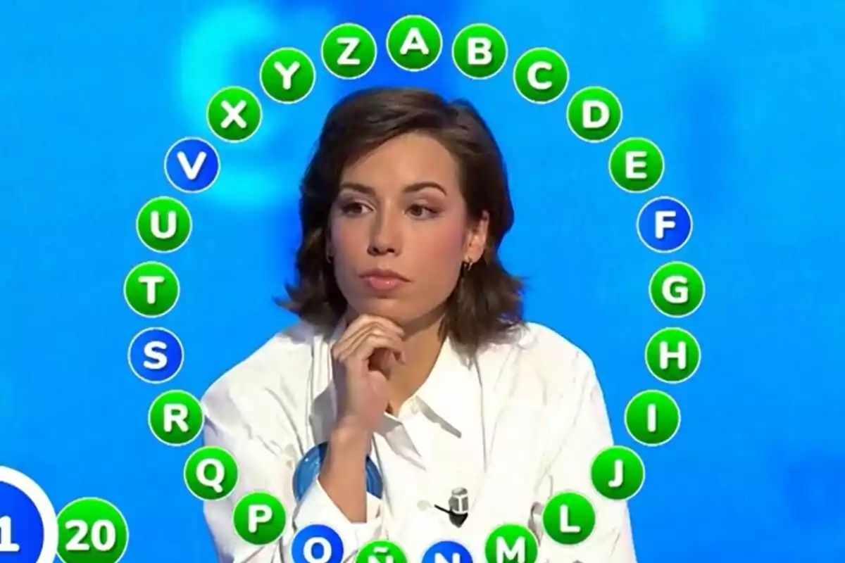 Rosa con expresión pensativa participa en Pasapalabra con un círculo de letras del abecedario a su alrededor. Rosa con expresión pensativa participa en Pasapalabra con un círculo de letras del abecedario a su alrededor.