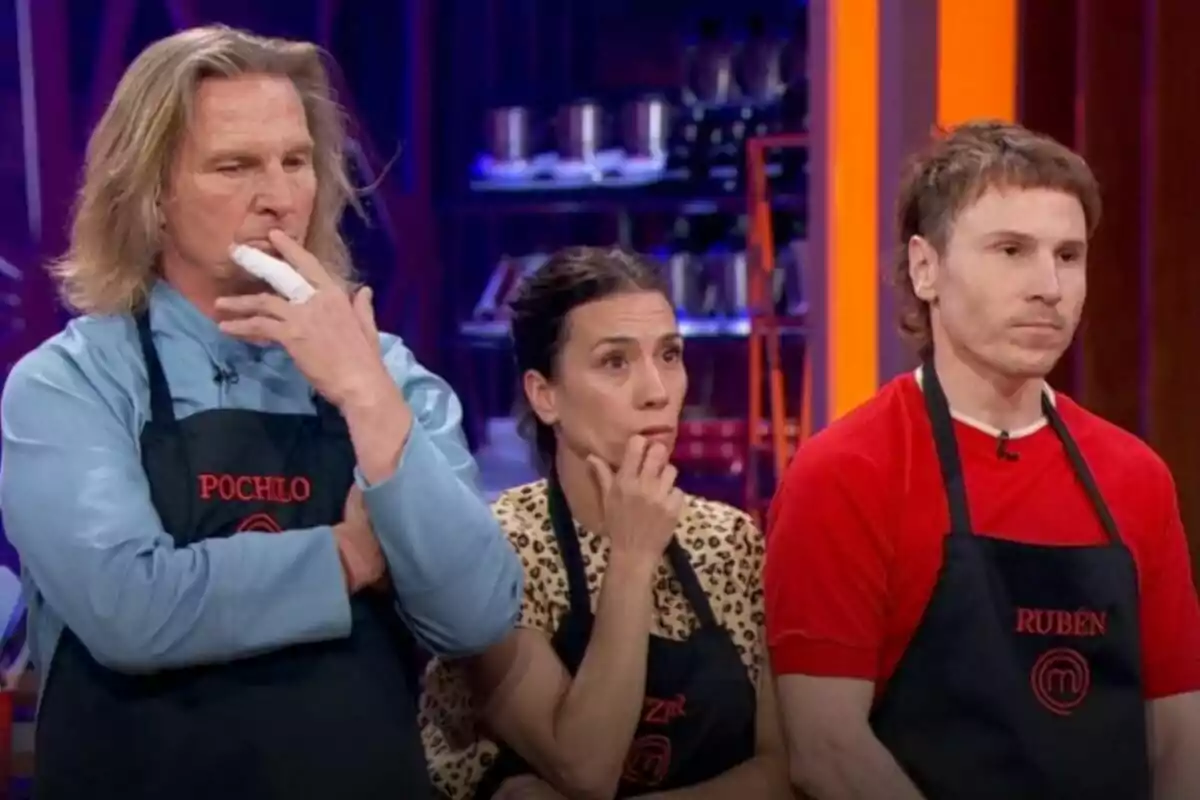 Pocholo Martínez Bordiú, Itziar Miranda y Rubén Ochandiano con delantales de cocina están de pie, mirando hacia adelante con expresiones serias y pensativas en MasterChef Celebrity. Pocholo Martínez Bordiú, Itziar Miranda y Rubén Ochandiano con delantales de cocina están de pie, mirando hacia adelante con expresiones serias y pensativas en MasterChef Celebrity.