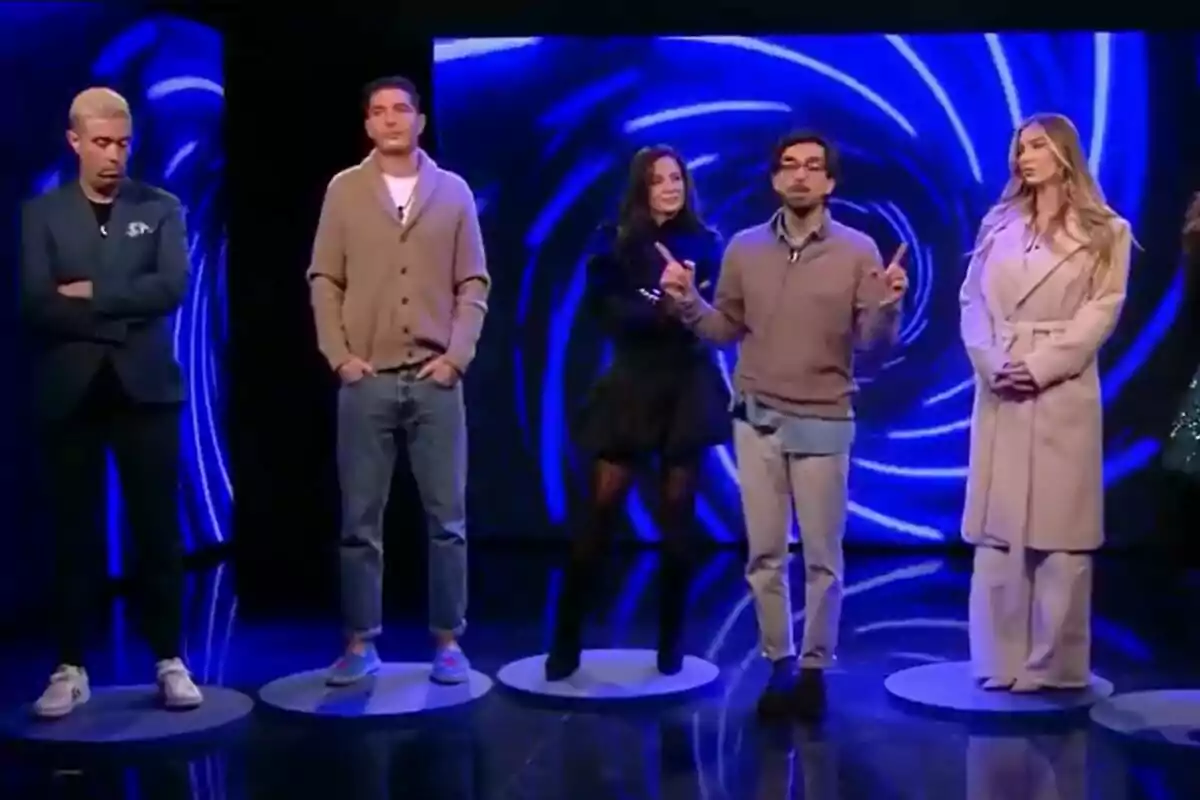 Javier Mouzo, Àlex Ghita, Ana Herminia, Dani Santos i Romina Malaspina de persones està dreta en un escenari amb un fons blau brillant a GH DÚO. Javier Mouzo, Àlex Ghita, Ana Herminia, Dani Santos i Romina Malaspina de persones està dreta en un escenari amb un fons blau brillant a GH DÚO.