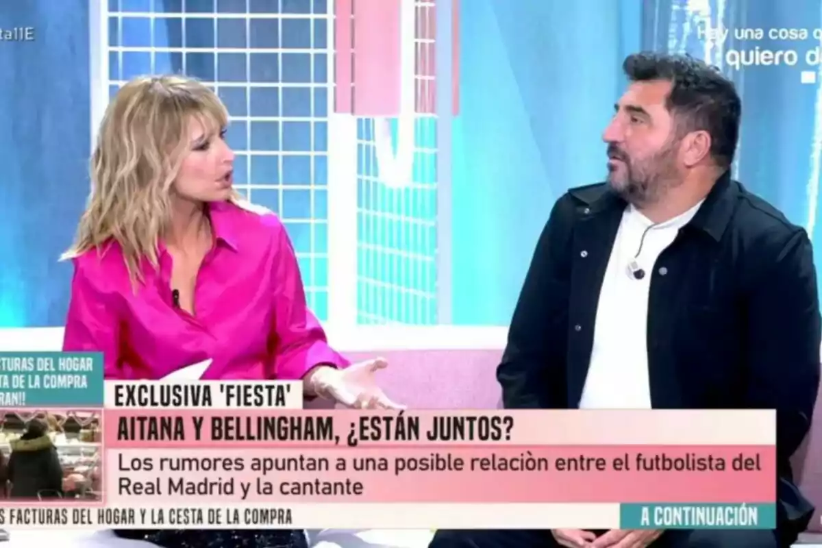 Emma García amb brusa rosa conversa amb Sergio Garrido vestit de negre en un Festa, mentre que a la pantalla es mostra un titular sobre rumors d'una possible relació entre un futbolista i una cantant. Emma García amb brusa rosa conversa amb Sergio Garrido vestit de negre en un Festa, mentre que a la pantalla es mostra un titular sobre rumors d'una possible relació entre un futbolista i una cantant.
