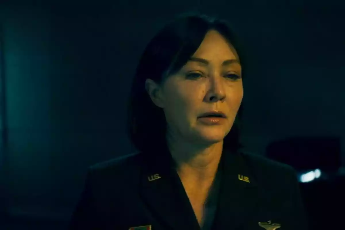 Shannen doherty con uniforme militar oscuro en una habitación con poca luz. Shannen doherty con uniforme militar oscuro en una habitación con poca luz.