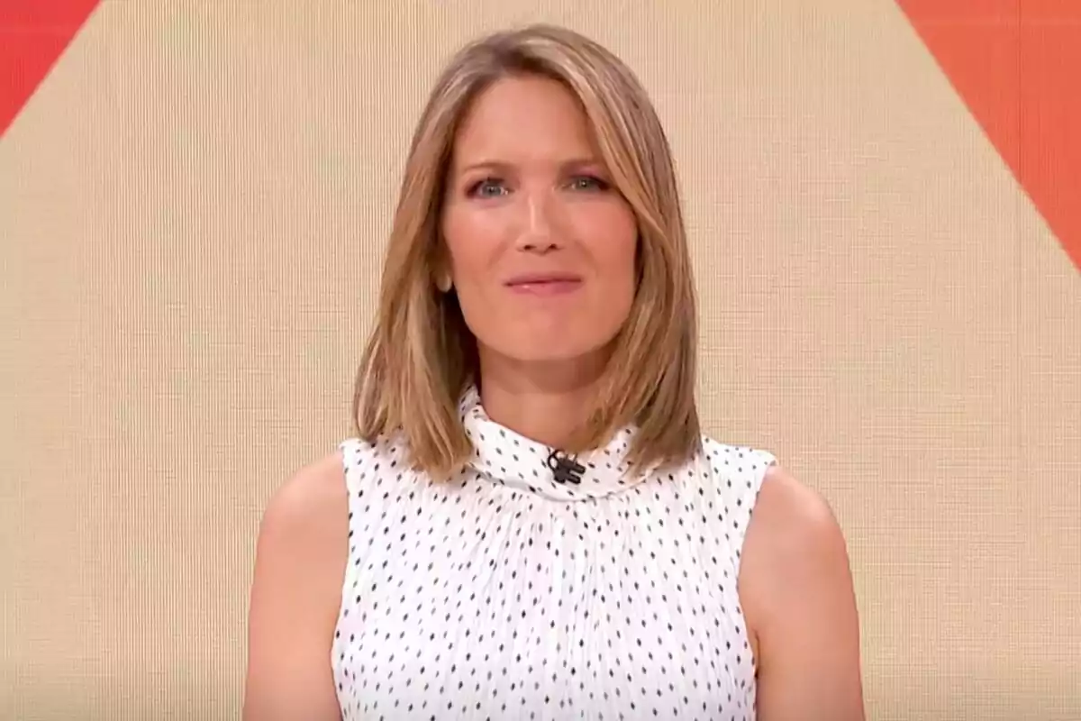 Captura de Silvia Intxaurrondo con cabello rubio y lacio, usando una blusa blanca con puntos negros, frente a un fondo beige con detalles en rojo en La Hora de La 1 Captura de Silvia Intxaurrondo con cabello rubio y lacio, usando una blusa blanca con puntos negros, frente a un fondo beige con detalles en rojo en La Hora de La 1