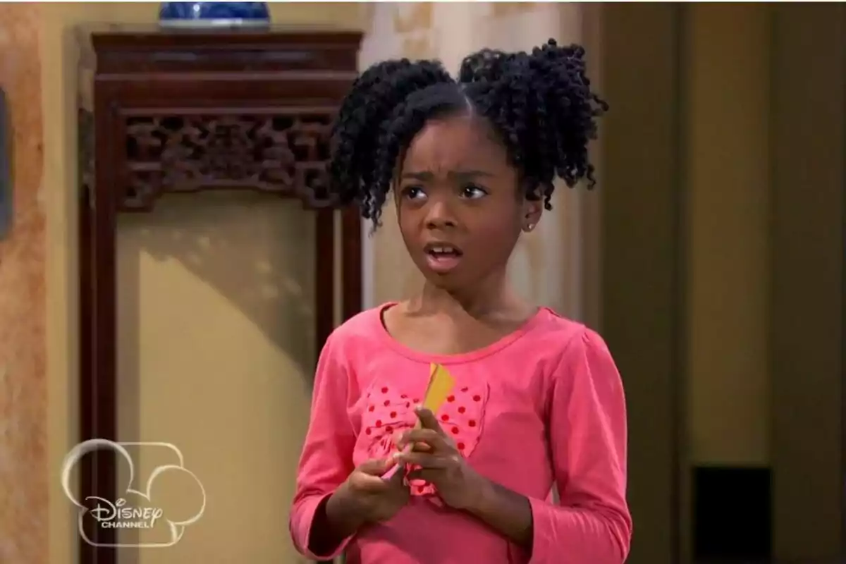 Captura de Skai Jackson amb expressió de sorpresa, vestida amb una samarreta rosa amb un llaç de lunars, sosté un objecte a les mans, a la sèrie Jessie amb el logotip de Disney Channel a la cantonada inferior esquerra. Captura de Skai Jackson amb expressió de sorpresa, vestida amb una samarreta rosa amb un llaç de lunars, sosté un objecte a les mans, a la sèrie Jessie amb el logotip de Disney Channel a la cantonada inferior esquerra.