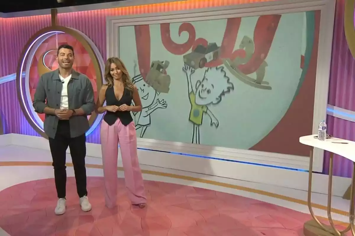 Antonio Santana i María Verdoy dempeus al set de 'Socialité' colorit amb una pantalla gran que mostra una animació de dibuixos animats. Captura de 'Socialité' el 29 de juny de 2024 Antonio Santana i María Verdoy dempeus al set de 'Socialité' colorit amb una pantalla gran que mostra una animació de dibuixos animats. Captura de 'Socialité' el 29 de juny de 2024