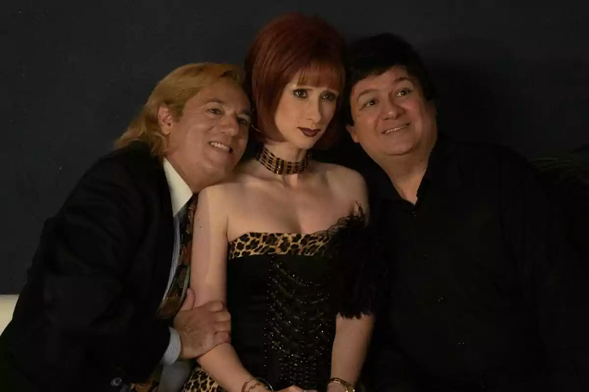 Ingrid Garcia-Jonsson como Yurenaa, Secun de la Rosa como Leonardo Dantés y Pepón Nieto como Tony Genil posan juntos, la del centro lleva un vestido de estampado animal print y los dos hombres a los lados sonríen mientras la rodean con los brazos en la serie Superestar
