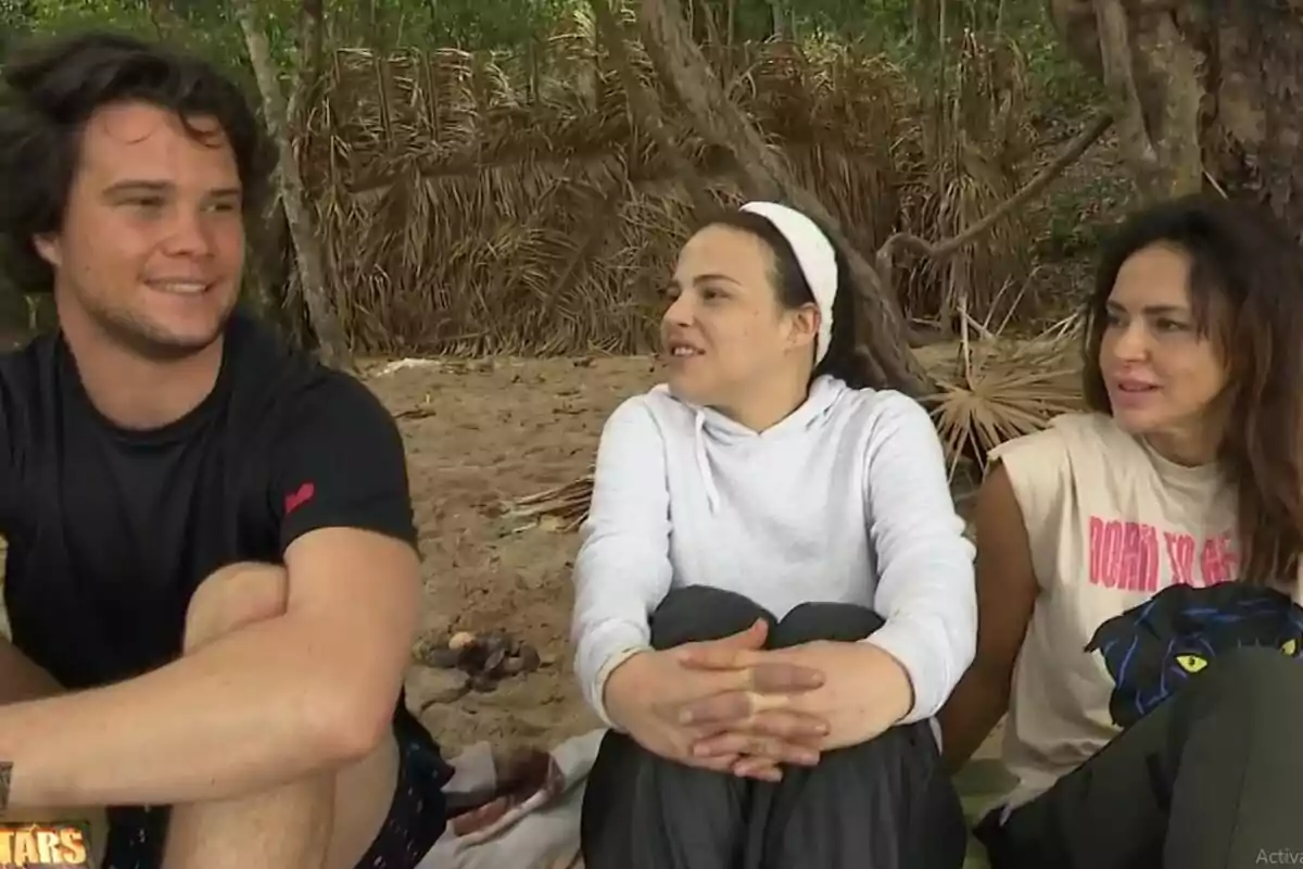 Bosco Martínez-Bordiú, Marta Peñate y Olga Moreno sentados en la playa conversando, con un fondo de vegetación y una estructura de hojas secas. Captura de 'Supervivientes' el 24 de junio de 2024 Bosco Martínez-Bordiú, Marta Peñate y Olga Moreno sentados en la playa conversando, con un fondo de vegetación y una estructura de hojas secas. Captura de 'Supervivientes' el 24 de junio de 2024